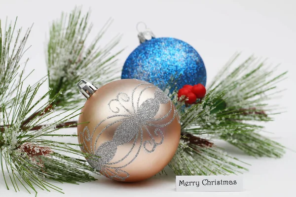 Frohe Weihnachtskarte mit bunten Christbaumkugeln und schneebedeckter Kiefer — Stockfoto