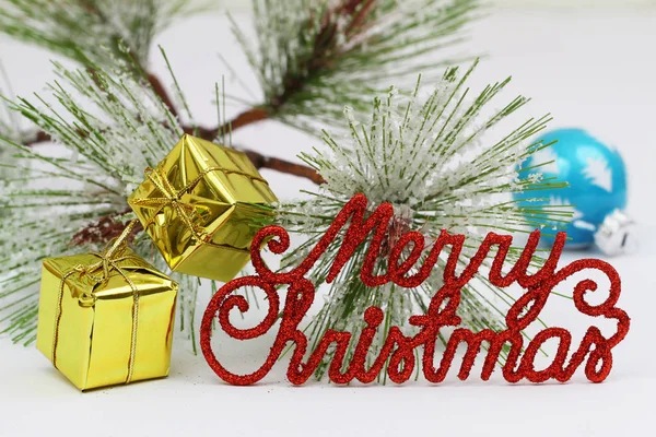 Wesołych Świąt z czerwonymi literami musujące, mini prezenty i sosna — Zdjęcie stockowe
