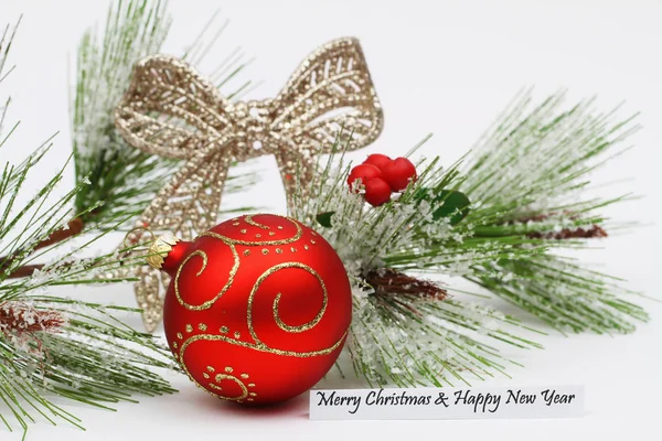 Feliz Natal e Feliz Ano Novo cartão com bauble vermelho e pinho coberto de neve — Fotografia de Stock