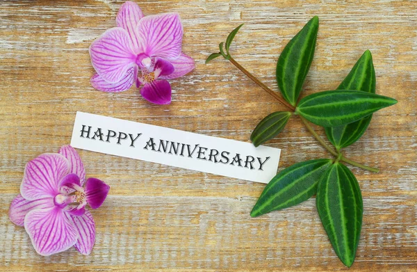 Happy Blahopřání Výročí Růžovými Květy Orchidejí Dřevěný Povrch — Stock fotografie