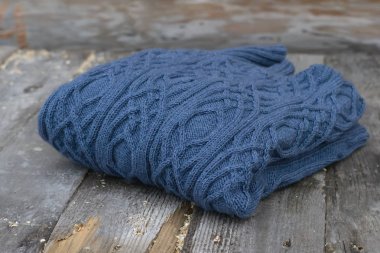 Sıcak kış örme kazak ahşap bir masa üzerine. Mavi renk