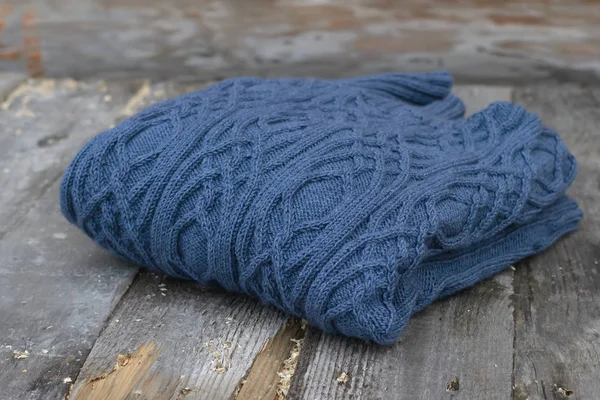 Sıcak kış örme kazak ahşap bir masa üzerine. Mavi renk