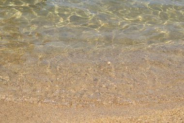 Kum plaj, kıyı şeridi ve kristal berraklığında su deniz.