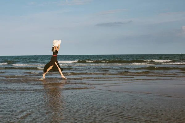 Mujer en sombrero blanco grande disfrutar de la libertad en el mar azul — Foto de Stock