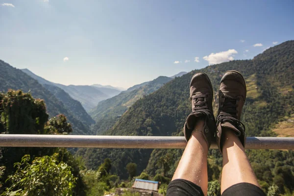 Jambes du voyageur assis dans les montagnes — Photo