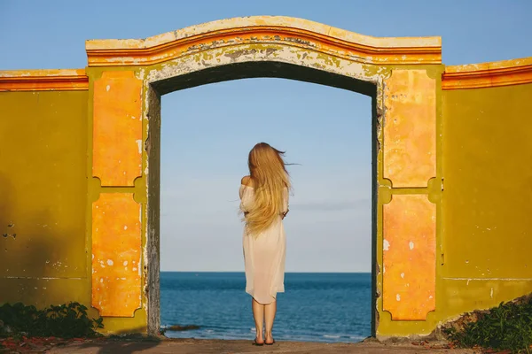 Chica en vestido blanco de pie en la puerta de edad —  Fotos de Stock