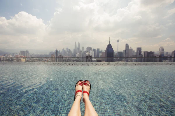 Pies en sandalias mientras nadan en la piscina de la azotea — Foto de Stock