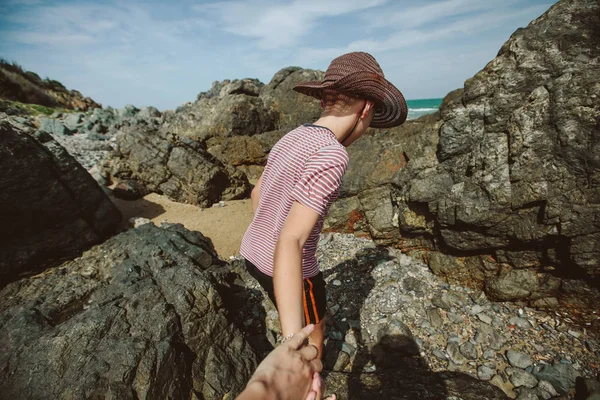 Menino segurando a mão e andando sobre pedras — Fotografia de Stock