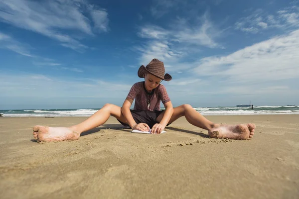 夏のビーチに座っている若い男の子 — ストック写真