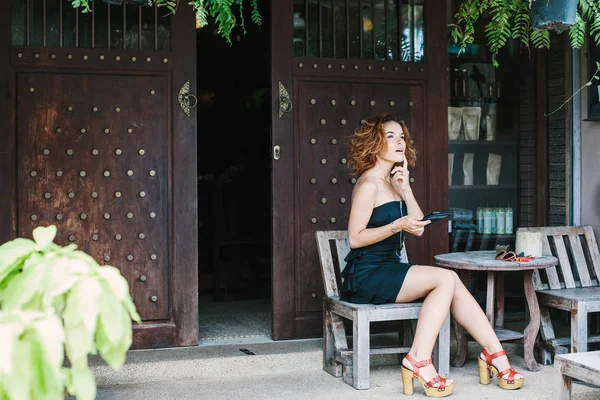 Chica joven sentada en la cafetería al aire libre — Foto de Stock
