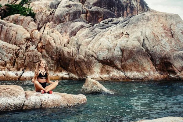 Молода жінка, сидячи Lotus позувати — стокове фото