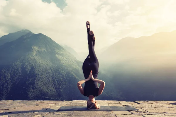 Jonge vrouw doen headstand — Stockfoto