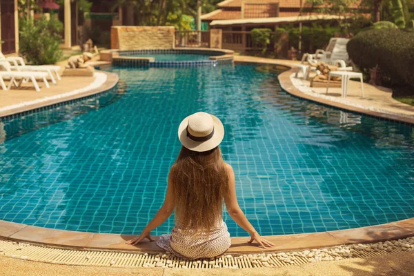 Mujer sentada cerca de la piscina — Foto de Stock