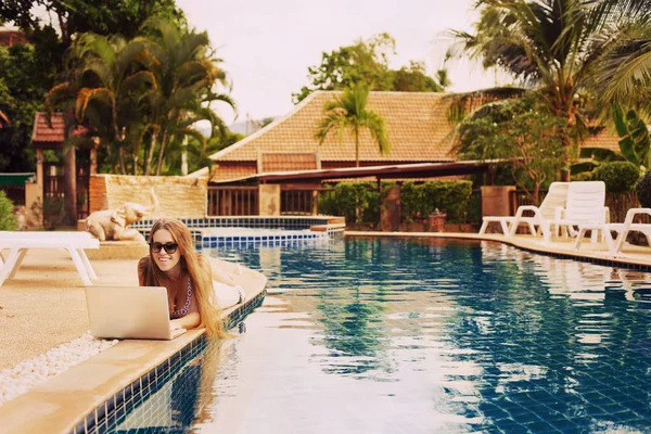 Jovem mulher usando computador portátil na piscina — Fotografia de Stock
