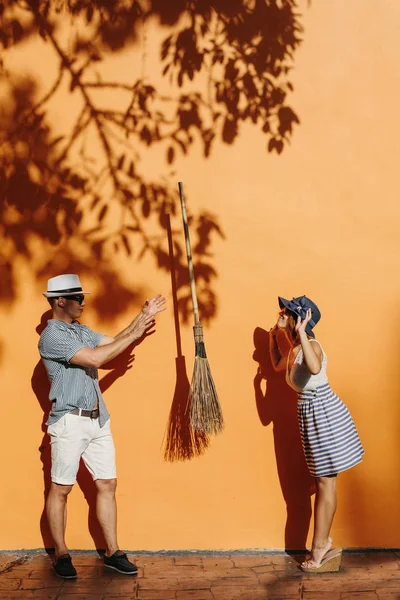 Casal ao ar livre jogando uma vassoura para o outro — Fotografia de Stock