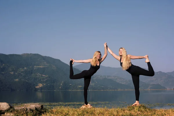 Twee blonde meisjes doen yoga oefening — Stockfoto