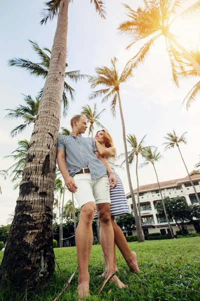 Jeune couple debout sous les palmiers — Photo