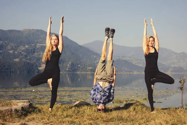 Young yogis doing yoga headstand — Stock Photo, Image