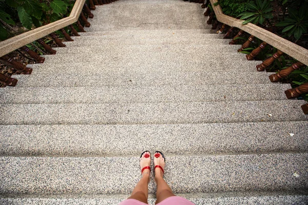 Female feet in sandals on the top of steps — Stock Photo, Image