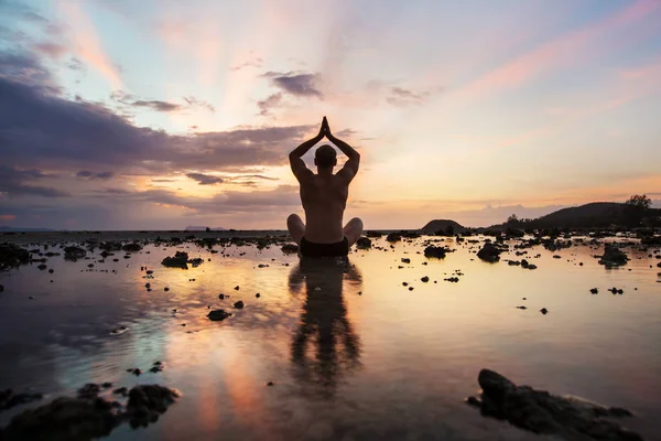 Silhouet man zittend op het strand — Stockfoto