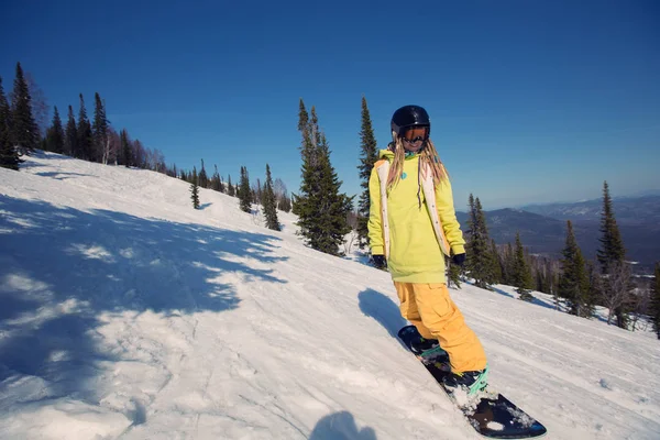 Vrouwelijke snowboarder verplaatsen op sneeuw — Stockfoto