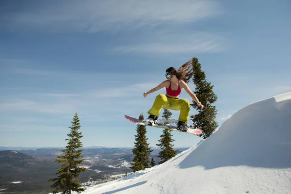 Mujer snowboarder saltando en snowboard —  Fotos de Stock