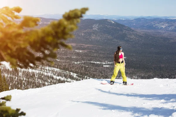 Mujer de pie en snowboard en la cima de la montaña . —  Fotos de Stock