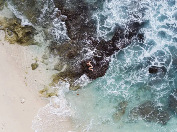 女性は海と崖 ヌサペニダ島 バリ島の間の海岸に横たわっています ドローンの空中風景 — ストック写真