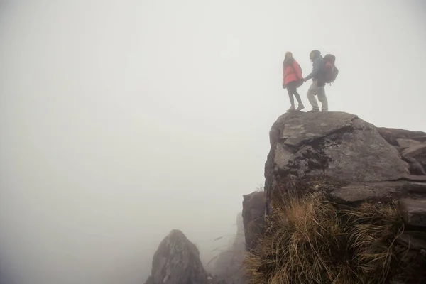 Pareja Excursionistas Con Mochilas Relajándose Cima Del Acantilado Montaña Niebla — Foto de Stock