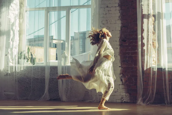 音楽を聴き 踊る大きな窓を持つ明るいインテリアの美しい女性 ホームコンフォートコンセプト — ストック写真