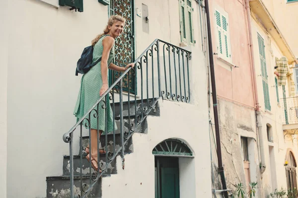 Laughing girl climbs the stairs to house from outdoor in European city