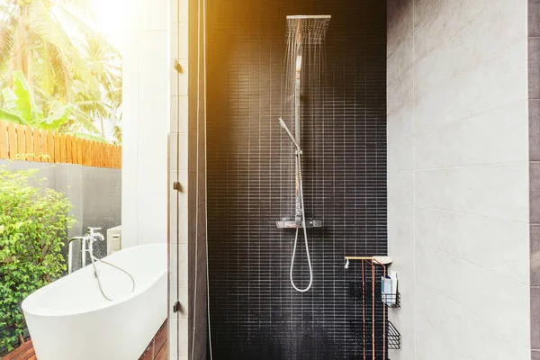 Bathroom in luxury villa interior. Bath outdoor, water coming from shower