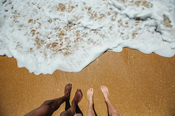 海の海岸 黄色の砂 晴れた日に混合レースカップル足 — ストック写真