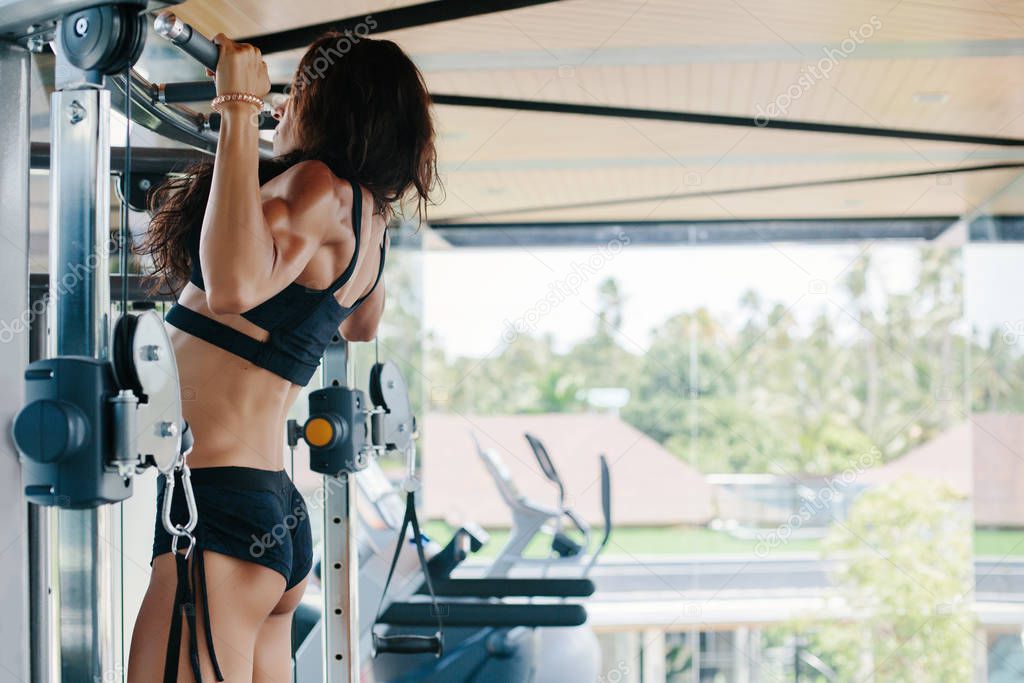 Beautiful Athlete female doing exercises in gym