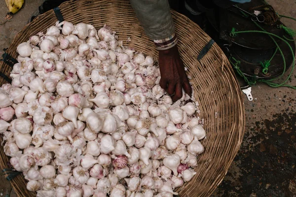 Garlic and seller hand in basket on street market