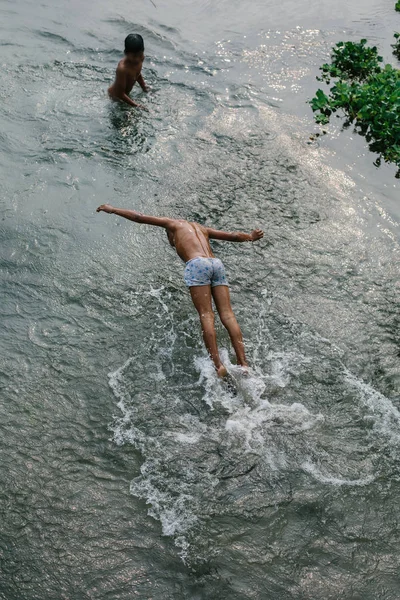 Kids jumping and swim in river. Happy children, childhood in village