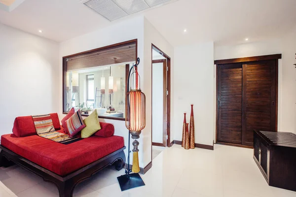现代卧房室内在昂贵的热带酒店度假胜地 红色沙发 红色大灯 木门和有大窗户的浴室 — 图库照片