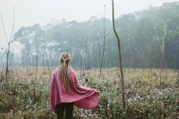 恐怖ロックとピンクの毛布を身に着けているブロンドの女性は霧のフィールドで歩く朝の時間 — ストック写真