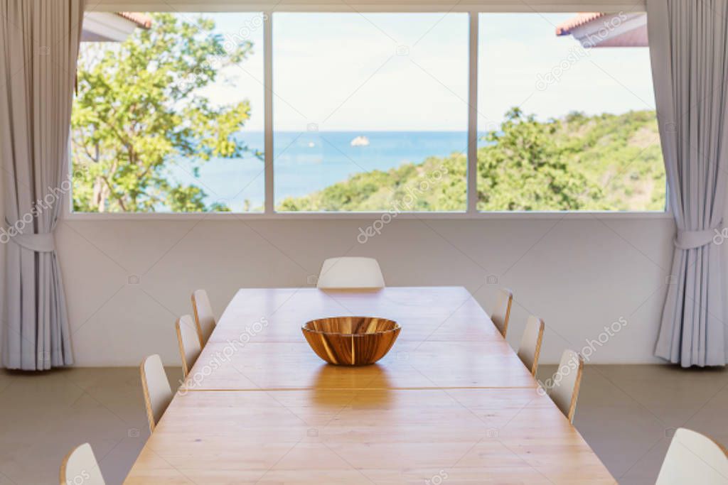 Desk and chairs on kitchen. Sea shore view in big window