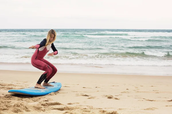 Веселый Позитивный Серфингистка Доской Серфинга Пляже Океана Делает Упражнения — стоковое фото