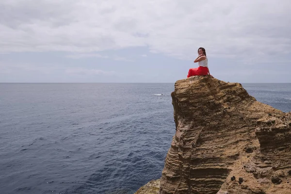 Дивовижна Жінка Червоній Сукні Капелюсі Стоїть Дивовижному Скелі Дивлячись Океан — стокове фото