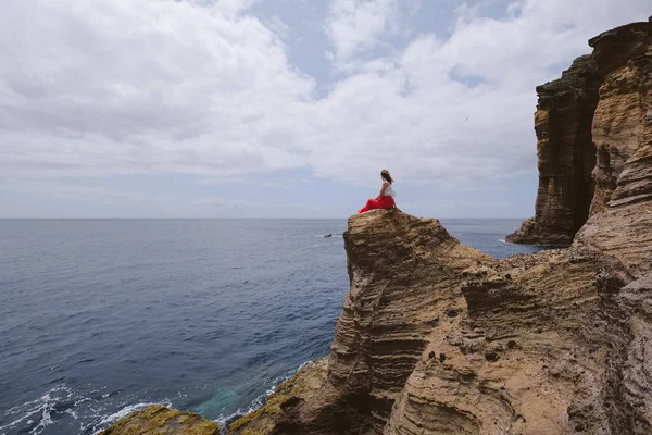 Дивовижна Жінка Червоній Сукні Капелюсі Стоїть Дивовижному Скелі Дивлячись Океан — стокове фото