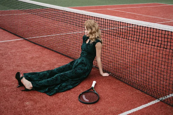 Luxury glamour fashion woman on tennis court holding racket and posing like model