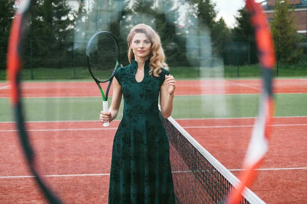Luxury glamour fashion woman on tennis court holding racket and posing like model