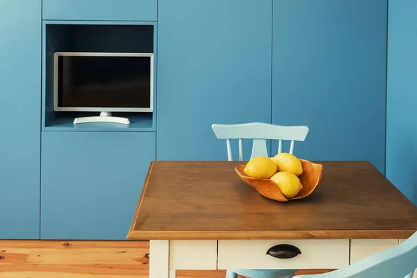 小さなアパートで最小限のインテリアデザインキッチン 青い壁小さなテーブルの上に黄色のレモン — ストック写真