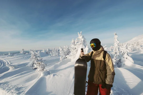 Snowboardos Mobiltelefont Használ Télen Hegyekben Gyönyörű Hófedte Fenyőerdő Háttérben — Stock Fotó