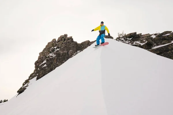 Сноубордист Едет Склону Держа Доску Белый Снежный Фон — стоковое фото