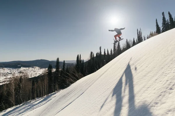 Silhouet Van Snowboarder Mannelijke Springen Boven Besneeuwde Ski Slop Zonnige — Stockfoto