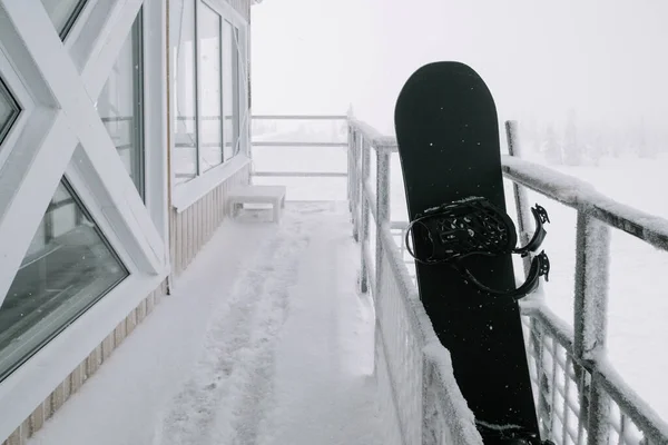 Zwarte Snowboard Staan Bevroren Huis Bedekt Met Sneeuw Winterdag Skigebied — Stockfoto