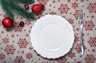 Vintage Noel tatil arka plan kırmızı Noel süsler (koniler, topları) ile tabağa. Tuval arka plan kırmızı glitter kar taneleri ile. Noel kartı. Yeni Yılınız Kutlu Olsun. Metin için yer